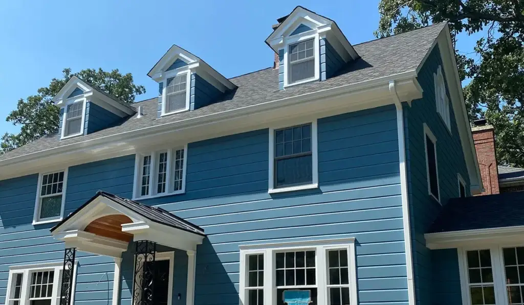 Two-story blue home with dormers and a clean roof in the Chicago suburbs
