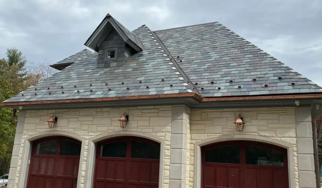 Finished slate roof with copper ridge flashing, built to last generations