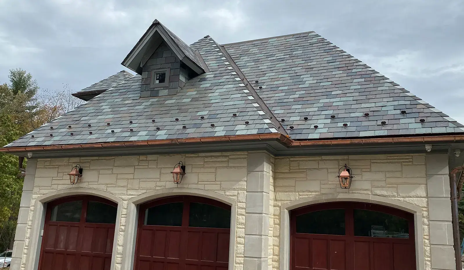 Finished slate roof with copper ridge flashing, built to last generations