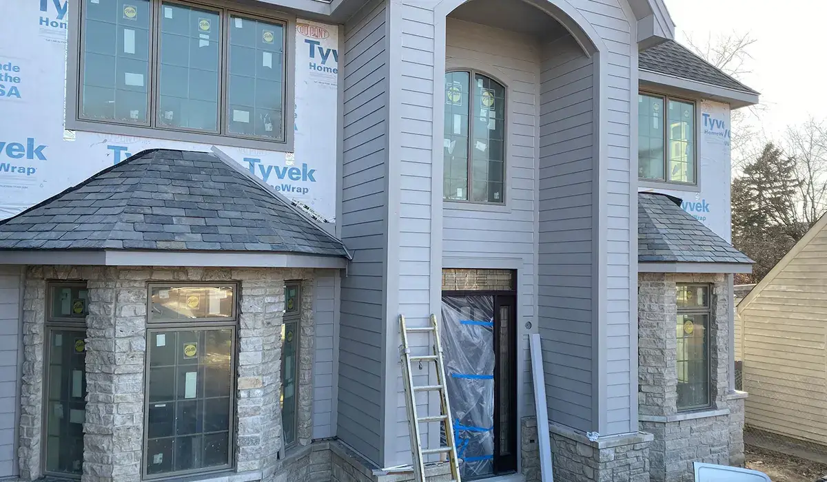 Whole home mid-project with a new asphalt roof and ladder in place