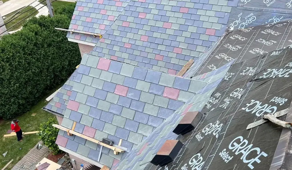 Roofing crew installing a multi-color slate roof, showing what a replacement looks like